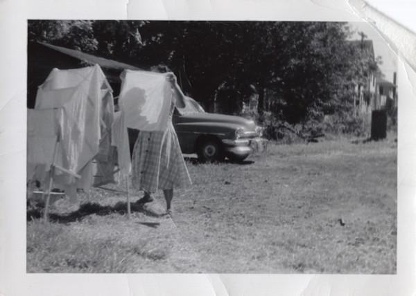 Woman hanging wash by Unknown