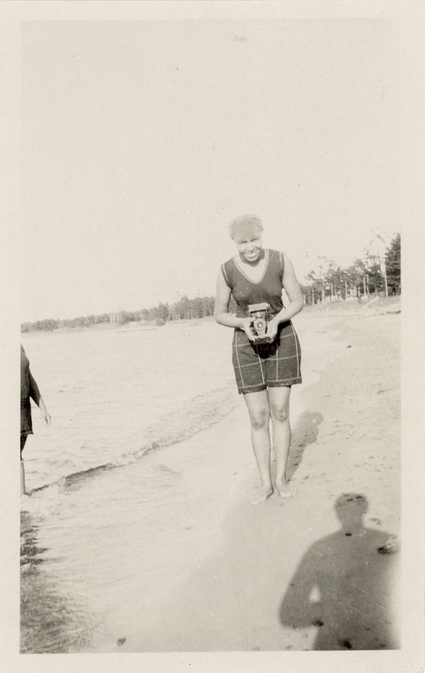 Woman photographing on the beach by Unknown