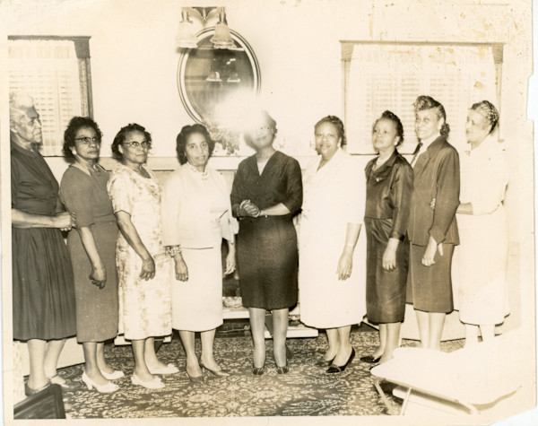 Women’s group standing in living room by Unknown