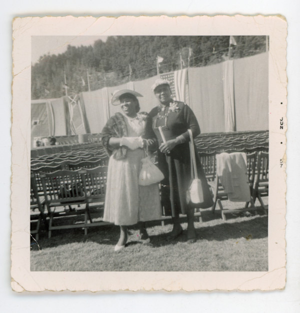 Two well-dressed women in empty outdoor venue by Unknown