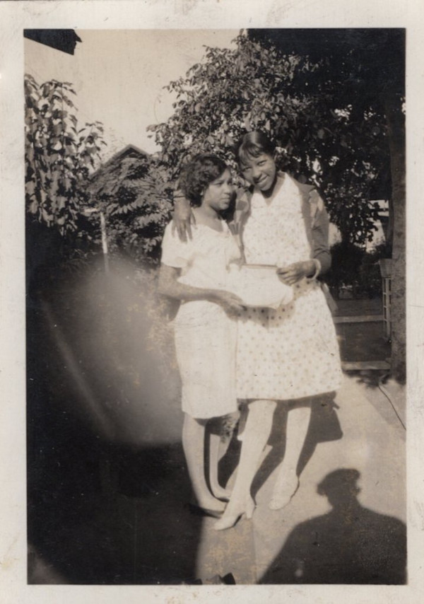 Two women embracing with photographer’s shadow by Unknown