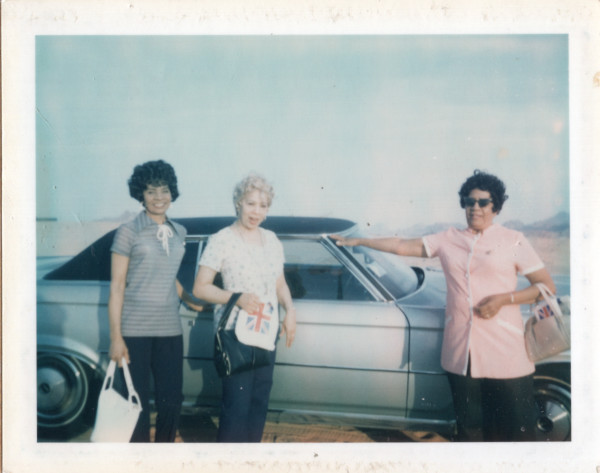 Three women by car by Unknown