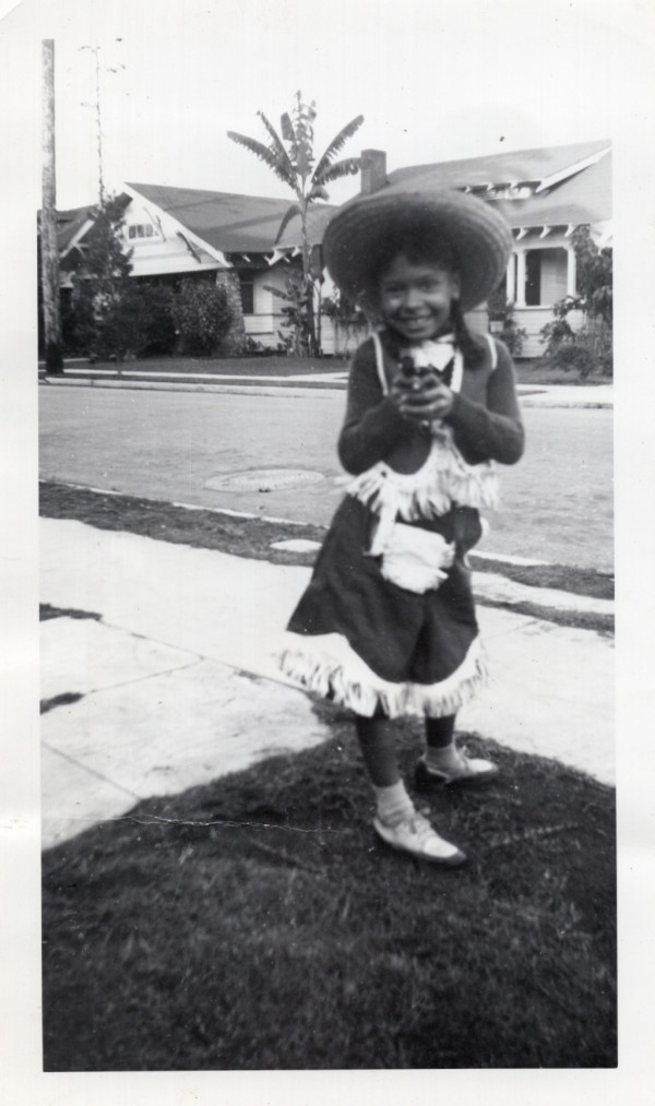 Girl in cowgirl costume pointing gun by Unknown