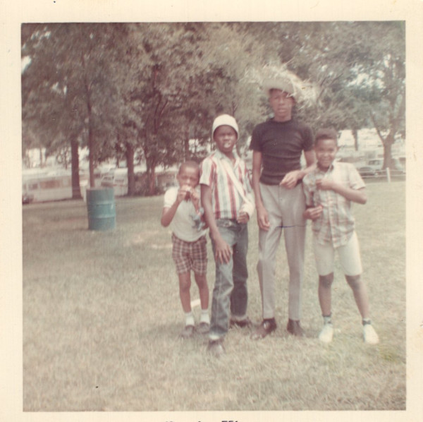 Four boys, one in straw hat, in the park by Unknown