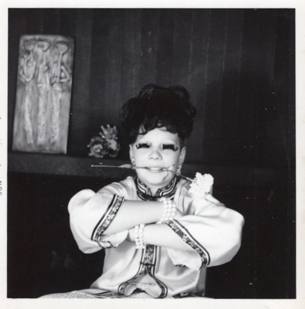 Woman in false eyelashes with carnation clenched in her teeth by Unknown