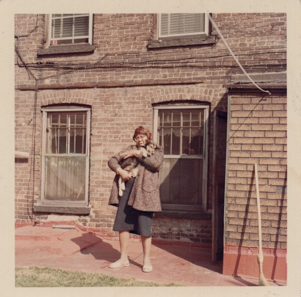 Woman holding dog by Unknown