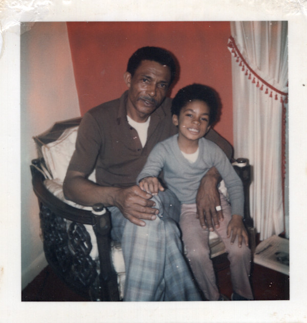 Man & boy seated in chair by Unknown