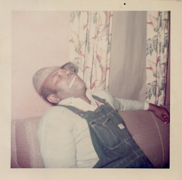Man wearing hat asleep with cigarette in his mouth by Unknown