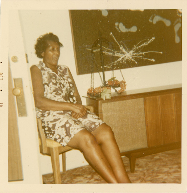 Woman sitting next to artwork with footprints by Unknown