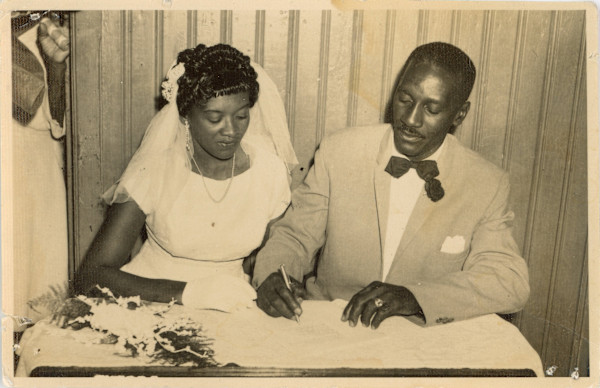 Bride and groom signing marriage license by Unknown