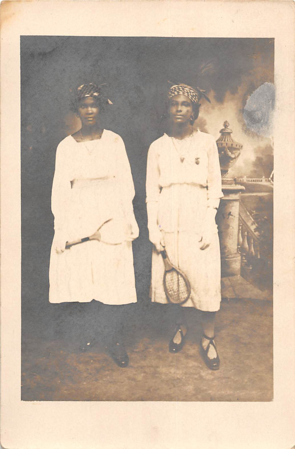 Two women posing in studio with tennis rackets by Unknown