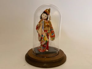 Small doll with drum under glass dome