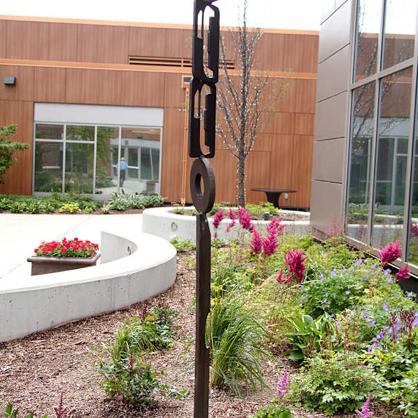 Totem-like rusted metal outdoor sculpture by Doris White, Image 1.