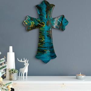 Holy Water by Debra Wilson  Image: The Light Within” — A fluid blend of color and spirit, this resin-on-wood cross glows with movement and mystery. Styled for the season with serene white and silver accents.
