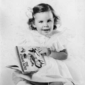 Photographs over the years by Amy Ione  Image: Probably around 3 years old.  Amy Ione was an avid book reader even before  she could read!
