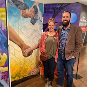 Kindness by Lindsey Veil  Image: Artist and husband next to the painting.