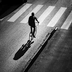Madrid - Cyclist and Shadow Riding Into the Light by Juan Matorras