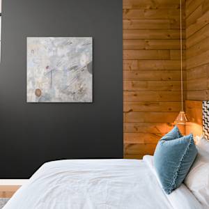 "Beach Dreams #1" by Steven McHugh  Image: Interior displayed view of "Beach Dream #1," it captures the ethereal beauty of the Apostle Islands through a harmonious blend of textures and colors. As a mixed-media, non-representational abstract piece, it invites endless interpretation, evoking the serene essence of Lake Superior's shores. Perfect for adding a touch of tranquility to any space, this artwork reflects the unique interplay of nature and creativity that defines my practice. Immerse yourself in the calming vistas of Madeline Island, each piece tells a story of artistic exploration and island-inspired wonder.

Painting is on unstrecthed canvas and is shipped rolled in a cardboard tube and includes strecther bars.  Shipping is included.

"Beach Dreams #1" is a  mixed-media abstract composition featuring a soft, muted background dominated by shades of beige, white, and light blue, creating an ethereal and textured surface. Various delicate lines and small shapes are scattered across the canvas, including thin black strokes, light pastel blue streaks, and faint circular forms. Two more prominent shapes stand out: an earthy reddish-brown oval near the lower left corner (beach rocks) and a darker, partially obscured gray-blue shape below it. The brushwork and layering give the painting a sense of depth and movement, with a harmonious blend of organic and geometric elements creating a contemplative, almost dreamlike atmosphere. Measuring 24" x 24" oil, grease pencil, pastel and graphite on canvas.