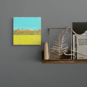 "Landscape #15" by Steven McHugh  Image: Room view of "Landscape #15," a small abstract landscape with bold color combinations on a wood panel by Madeline Island artist Steve McHugh. This distinctive piece, crafted with oil and cold wax, measures 8" x 8" x 2.5" and offers versatility as it can be hung or set on a shelf. The composition brings the essence of nature to life, featuring the lower half with textured yellow and green long grasses, a middle section showcasing a line of green trees, and a forest behind and sky blue behind. Each stroke reflects the serenity and vivid beauty of the Apostle Islands, making it a unique addition to any space. Explore more at stevemchughart.com and bring a touch of Madeline Island's charm into your home. Shipping in the U.S. is included.

This abstract landscape painting has a simple, yet vibrant composition. The bottom portion of the painting features a wide expanse of yellow, suggestive of a field or meadow. Above this strip of yellow, there is a stretch of muted green and orange hues forming a horizontal band, reminiscent of distant hills. The sky dominates the upper half of the composition, rendered in a striking, clear blue with subtle textures adding depth and movement. The use of color is bold, and the brushstrokes are expressive, creating a sense of both tranquility and dynamism in the landscape.