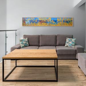 "Big Bay Road" by Steven McHugh  Image: Interior installation view of "Big Bay Road,"  a panoramic landscape painting featuring a dense forest composed of tall, slender trees with white trunks and autumnal foliage in vibrant shades of gold, orange, and yellow. The trees create vertical lines that contrast against a deep blue background suggesting a clear sky and distant water. The composition balances the bright, warm colors of the leaves with the cool blue tones, creating a striking visual effect. The scene conveys a serene atmosphere with an abstract, almost impressionistic style, emphasizing color and form over detailed realism.

Immerse yourself in the essence of Madeline Island with "Big Bay Road," a mixed-media abstract piece crafted by Madeline Island's resident abstract painter, Steve McHugh. This evocative artwork captures the untamed spirit of the Apostle Islands, bringing the ethereal beauty of Lake Superior to your space. Each brushstroke and texture uniquely conveys a non-representational journey through the island's rugged landscapes. Perfect for art enthusiasts seeking a vibrant, dynamic accent for their home or office, "Big Bay Road" embodies the rich, scenic splendor of Wisconsin's northern wilderness. Transform your interior with this compelling piece that resonates deeply with the natural world.

This oil and cold-wax painting is on a wood panel and measures 12 x 72" x 1.5", framed in a gallery floating frame measures 13" x 73" x 2.5". Shipping is included in the lower 48 U.S. states.