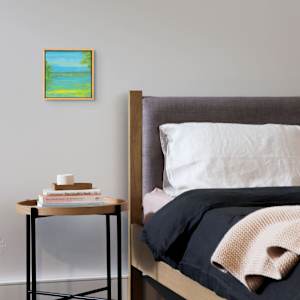 "Tranquil" by Steven McHugh  Image: Interior view of "Tranquil," a mesmerizing piece crafted by mixed-media artist from Madeline Island. Reflecting the ethereal charm of the Apostle Islands in Lake Superior, this representational abstract painting embodies a unique harmony that invites calm and introspection. At stevemchugh.art, our dedication to creating emotionally resonant art is evident, and "Tranquil" stands as a testament to our commitment to quality and vision. Elevate your space with this captivating work that seamlessly blends textures and colors to evoke a sense of peaceful surrender. 

"Tranquil" is a serene landscape painting depicting a calm body of water surrounded by greenery. The water reflects varying shades of blue and green, creating a tranquil effect. On both the left and right edges of the scene, dense clusters of green foliage frame the water. The sky above is painted in soft blue hues with subtle hints of light clouds, adding depth to the composition. The overall color palette emphasizes cool tones with touches of warm yellow near the water’s edge. The painting is enclosed in a simple wooden frame that complements the natural theme of the artwork.

This oil and cold-wax painting on wood is framed in a 10.5" x 10.5" x 2.5" gallery floating frame.