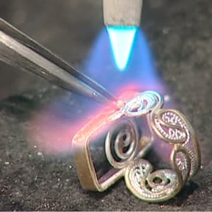 Lumiere by Victoria Lansford  Image: Soldering the 18k gold balls where the shank meets the bezel