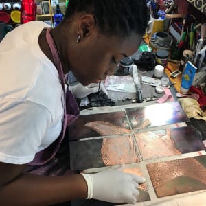 Etched Copper Room Divider for Superyacht's Main Saloon by Victoria Lansford  Image: Uduak applying the waxed pigment to the recessed areas