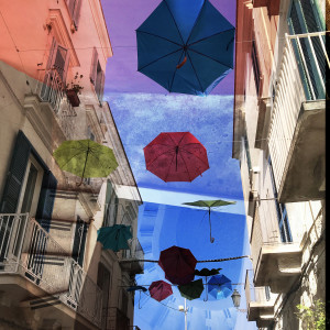 Hallucinations: Trani Puglia with Umbrellas Red and Blue by Bonnie Levinson