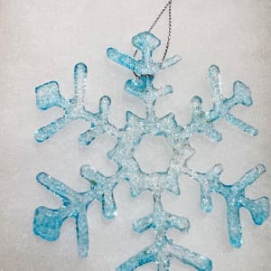 Snowflake Ornaments- 4-1/2" $30. 5-1/2" is $35 Call for current selection by Nancy Gong  Image: Let it snow. Let it snow. Let it snow. Add some sparkle to your Winter Season! Glass snowflake ornaments for hanging in a window or on a tree are made of ground glass that is melted at high temperatures into snowflake designs. Dispersement of color and visual and physical texture will vary slight from snowflake to snowflake. See sample options below.  Each snowflake will be unique. Make your selection and contact the studio. Shipping is available.
Shown is 4-1/2" $30.00 in Clear and turquoise with a granular snow finish.
Approx 1/8" thick. Each are unique.