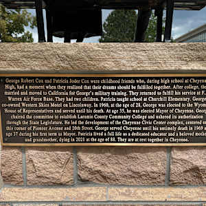 How Do Such Things Begin? From Our Town by Joel Turner  Image: Placard on back of bronze base: "George Robert Cox and Patricia Joder Cox were childhood friends who, during high school at Cheyenne High, had a moment when they realized that their dreams should be fulfilled together. After college, they married and moved to California for George's military training. They returned to fulfill his service at F.E. Warren Air Force Base. They had two children. Patricia taught school at Churchill Elementary. George co-owned Western Skies Motel on Lincolnway. In 1960, at the age of 28, George was elected to the Wyoming House of Representatives and served until his death. At age 35, he was elected Mayor of Cheyenne. George chaired the committee to establish Laramie County Community College and ushered its authorization through the State Legislature. He led the development of the Cheyenne Civic Center complex, centered on this corner of Pioneer Avenue and 20th Street. George served Cheyenne until his untimely death in 1969 at age 37 during his first term as Mayor. Patricia lived a full life as a dedicated educator and a beloved mother and grandmother, dying in 2021 at the age of 88. They are at rest together in Cheyenne."