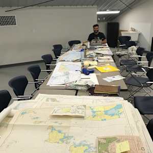 How I Go to the Woods by Susan Antoinette  Image: Gio’s Typos at the end of the planning session table, typing the Mary Oliver poem on the nautical chart. 