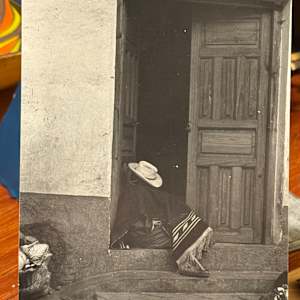 black and white photograph seated figure in a doorway 