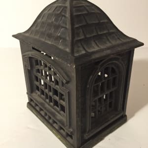 vintage iron penny bank in the shape of a bank 