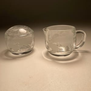Set of clear creamer and covered sugar with world motif 