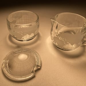 Set of clear creamer and covered sugar with world motif 