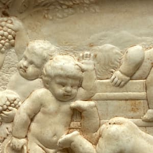 Framed relief of wine drinking cherubs 