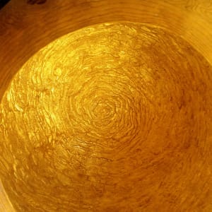 Riverbowl III by Serena Kovalosky  Image: Photo #10
Working with gold! 
For this Riverbowl, I wanted to capture the effect of looking down into the shallow part of the river with the sun shining through the water and lighting up the riverbed. Sparkly and magical! 

To achieve this, I had carved the interior of the gourd to resemble the flow of river currents. I then gilded the interior with a brass alloy leaf to bring warmth to the interior and create the effect of the sun shining through the water. It took a full booklet of brass leaf - 25 squares, each 5.5 inches x 5.5 inches - to cover the interior of the gourd, requiring a meticulous placement of each leaf and carefully pressing it into all the crevices. It's very meditative work - which is why I never meditate.

This gold-colored alloy leaf, also called Dutch metal leaf, is a mixture of copper and zinc and comes in different shades of gold, depending on the percentage of copper in the alloy. The brass leaf I selected for this piece contains 85% copper and 15% zinc, giving it a nice, warm hue that's not too orange and not as "lemony" as other alloy mixtures. As it is not a pure gold, it will age over many, many years. This is intentional to reflect the natural cycles of nature. 

Once the gilding adhesive is fully cured, the interior will be sealed with a varnish to offer maximum protection.

Next I will pull out my REAL gold leaf for the final design work on the exterior of the Riverbowl. 