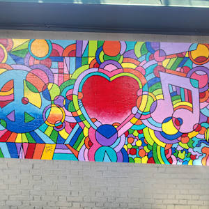 2025 Mural Slam by Jess Clark, Paige Doyle-Elwell, Sarah Egan, Naijah Garrett, Howie Green, Colomba Klenner, Caoin O'Durgy, Bruce Orr, Daphne Powers, Max Pro, Bobbie Smith, Jennifer Wackerle  Image: Peace, Love, & Music by Howie Green