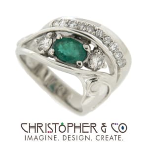 CMJ A 22006  Gold ring set with diamonds and one emerald designed by Christopher M. Jupp