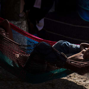 Asylum-seeking father and son sleep in an encampment near the International Bridge in Matamoros, México by Verónica G. Cárdenas