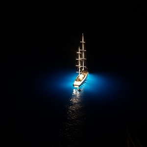 Sailboat at Night in Santorini by Lawrence Bridges