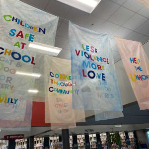 Our Wishes by Alejandra Abad  Image: "Our Wishes" by Alejandra Abad, 2022. Bemis Public Library main lobby (side view of second row of flags)