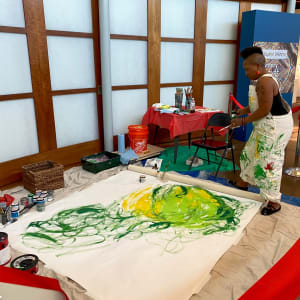 The Growing Spirit of Creative Communities by Quana Madison  Image: "The Growing Spirit of Creative Communities," painting by Quana Madison, 2023; image shows artist in early stages of live painting demonstration. 