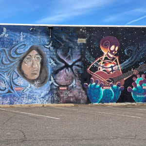 Untitled - skeleton playing guitar near cactus by Daniel Gonzalez  Image: East wall of Reinke Bros. building, showing works by Jerry & Jay Michael Jaramillo at left, and Daniel Gonzalez at right, image taken 2022.