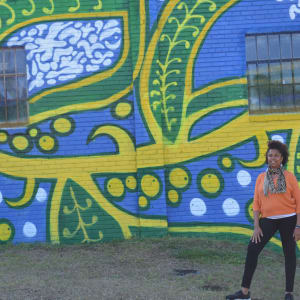 Grow Together by Charmaine Minniefield  Image: Artist in front of mural 