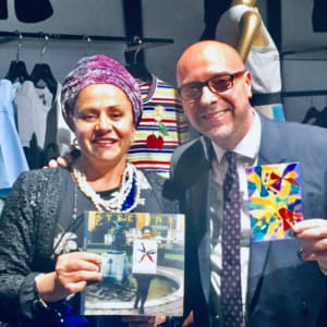 Autobiographic Pictures by Renee Fabbiocchi  Image: 2017, Tokyo - For my 60th birthday, Jonas wanted to invite me for a trip to Japan. 
Countless magical experiences rejuvenated my life, which had been weakened by conflicts within my two families. The most fabulous was the evening I met Alfonso Dolce, CEO of Dolce & Gabbana, in Tokyo. 
I remember how Jonas and I had visited Aoyama Cemetery, persistently searching for my address in NISHI AZABU in ROPPONGI. What wonderful memories! 
As we walked up Aoyama Dori to Omote Sando, intrigued by the festive people, music, and lights outside a boutique, I entered and found myself near the famous Alfonso. I immediately told him about my biographical brother, hoping he might replace him in my idea of a cosmic FAMILY. He smiled and willingly listened to my story, posing for this photo. He wished me JUSTICE and blessed my "STELLINA" project, expressing his admiration for my ART for CHILDREN and giving me his business card. Page 210 of my Autobiography 

2017, Tokyo - Per i miei 60 anni Jonas volle regalarmi un viaggio il Giappone. Tantissime esperienze magiche ritemprarono la mia vita indebolita dai conflitti delle mie due famiglie. 
La più favolosa fu la sera che conobbi Alfonso Dolce, CEO di Dolce & Gabbana, a Tokyo. Ricordo come io e Jonas eravamo stati a visitare il Cimitero di Aoyama cercando con insistenza il mio Indirizzo di NISHI AZABU a ROPPONGI. Quanti bei ricordi! 
Nel risalire la Aoyama Dori a Omote Sando, incuriosita dalla gente festosa, dalla Musica e dalle Luci davanti ad una Boutique, entrai e mi ritrovai vicino al famoso ALFONSO. Gli dissi subito del mio fratello biografico sperando volesse sostituirlo nella mia Idea di faMIGLIA cosmica. Sorrise e si prestò ad ascoltare la mia storia e a fare questa foto. Mi augurava GIUSTIZIA tenendo la mia Opera omonima in cartolina in mano e benedicendo la mia STELLINA  dichiarò la sua stima per la mia ARTE per BAMBINI dandomi il suo bigliettino da visita. Pagina 210 Autobiografia