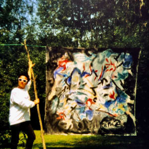 Autobiographic Pictures by Renee Fabbiocchi  Image: 1988, Austria - Thanks to the invitation of an engineer of the Residenztheater whom I met there, I spent a wonderful week at his Austrian residence near Lake St. Wolfgang. The agreement was based on a purchase proposal if I created a work that interested him. This photo captures me in his garden with a sketch of the canvas that he eagerly bought.
It was a week of purification in nature. In the mornings, I would wake up early to immerse myself in the forest nearby (Shinrin Yoku - forest bathing). Then, I practiced yoga, meditation, and painted. In the afternoons, I gladly accepted the invitation of a medical student I had met there to attend my beloved rustic parties with concerts and bonfires in nature. What a marvel! I returned to Munich exactly on August 23, a date that was to literally change my entire life.
Page 103 of my Autobiography

1988, Austria - Grazie all'invito di un ingegnere che aveva lavorato per il Residenztheater, dove ebbi la fortuna di conoscerlo, trascorsi una bellissima settimana nella sua residenza austriaca, vicino al lago di St. Wolfgang. L'accordo era basato su una proposta d'acquisto nel caso avessi creato un'opera che poteva interessarlo. Questa foto mi ritrae nel suo giardino con uno schizzo della tela che lui acquistò con entusiasmo. 
Fu una settimana di purificazione nella natura_ la mattina mi alzavo presto per immergermi nella foresta adiacente (Shinrin Yoku - bagno della foresta). Poi facevo yoga, meditazione e dipingevo. Nel pomeriggio mi lasciavo invitare volentieri da uno studente di medicina che avevo conosciuto lì alle mie tanto amate feste bucoliche con concerti e falò nella natura. Che meraviglia! Tornai a München esattamente il 23 agosto: data che doveva cambiare letteralmente tutta la mia vita. 
Pagina 103 Autobiografia 