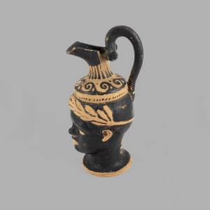 Oinochoe with beaked spout and small black rotelles. 