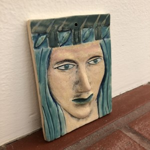 Turquena, a blue haired woman wall hanging woman, with hat by Nell Eakin 