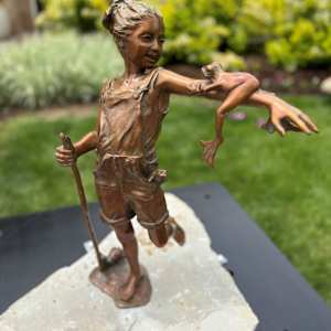 Froggy Summer Day by Bobbie Carlyle  Image: The endearing “Froggy Summer Days” sits outside The Schoolhouse. Bobbie shares that this darling piece was created as part of a 24-hour sculpture competition in Green River, Wyoming, where artists were asked to incorporate water as a theme. She said a cute girl stopped by during the competition and agreed to be her model. “It was a fun, if tiring, weekend.”
We are so lucky to have this piece to add to this year’s installs and think it’s sure to be as popular as her other permanent pieces here, including “Puppy Dog Tales” (Xeric Park) and “Self Made Man” (Living Wheel Park).